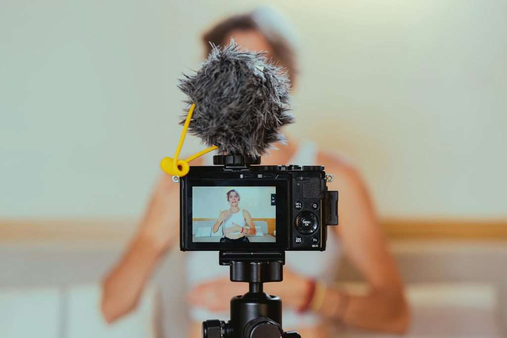 Shallow focus photo of a video camera recording an elderly woman